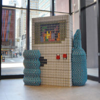 Canstruction build created with canned goods depicting hand holding a Nintendo Gameboy playing Tetris thumbnail